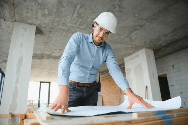 Engenheiro analisando projeto durante obra predial em Balneário Camboriú